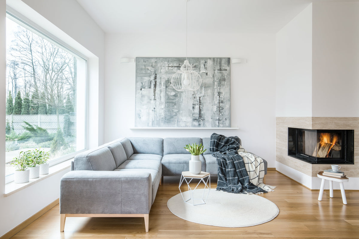 A calm, uncluttered Scandinavian-style living room with a grey sofa